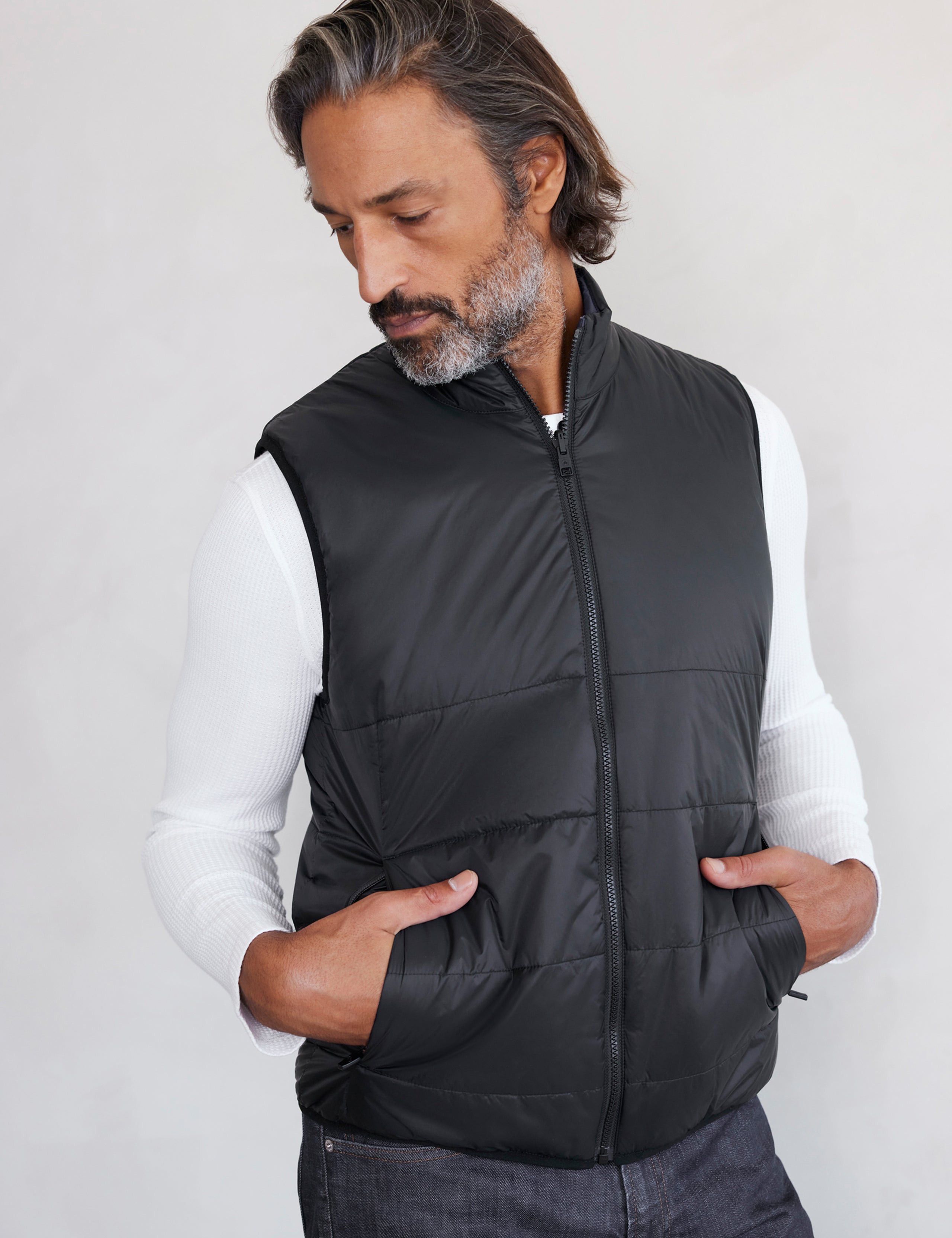 man wearing black side of reversible insulated vest