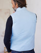 man wearing blue side of reversible insulated vest