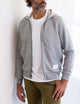 man wearing a light grey full zip hoodie