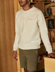 man wearing a beige crew neck with pocket
