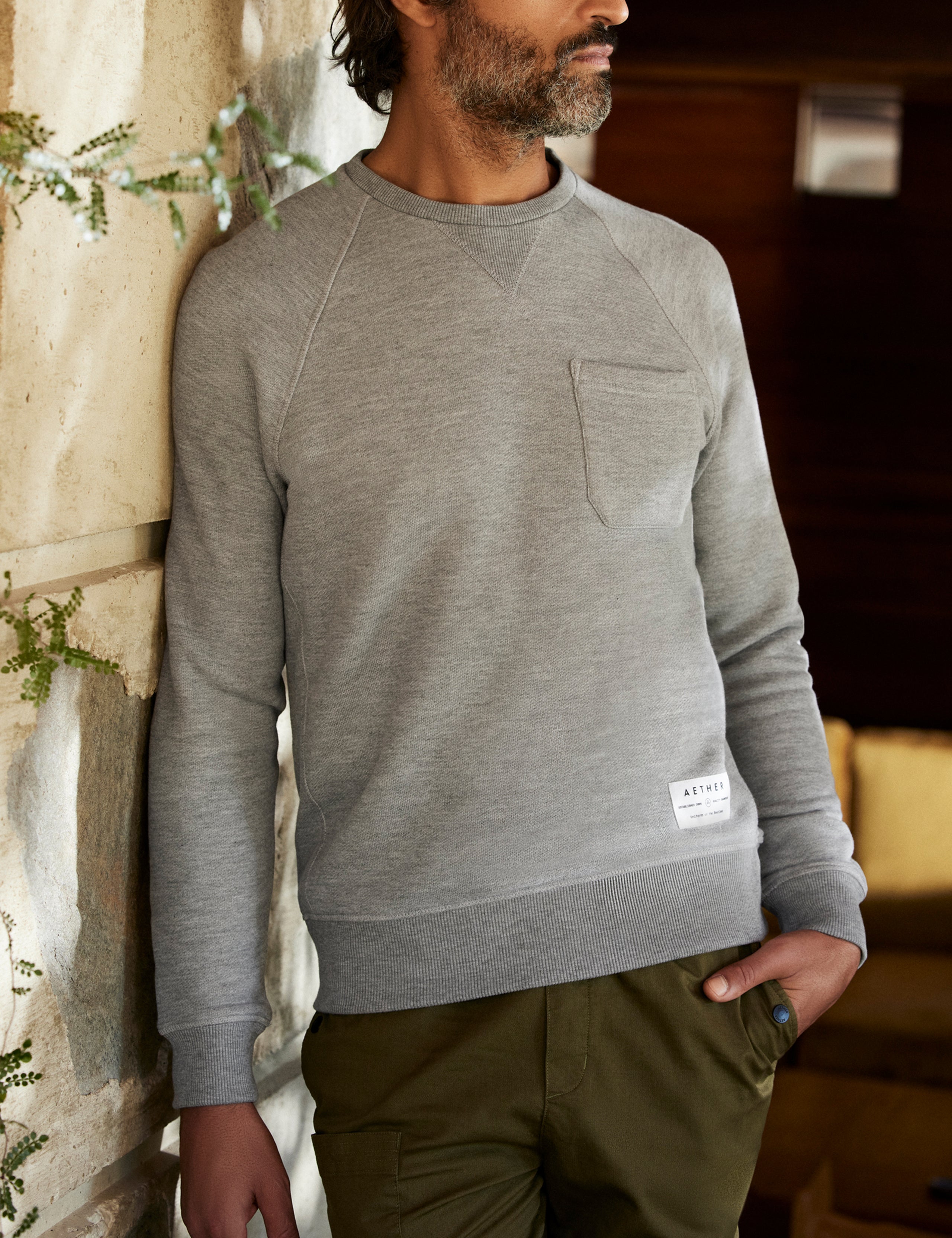 man wearing a grey crew neck with pocket