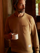 man wearing a brown crew neck with pocket