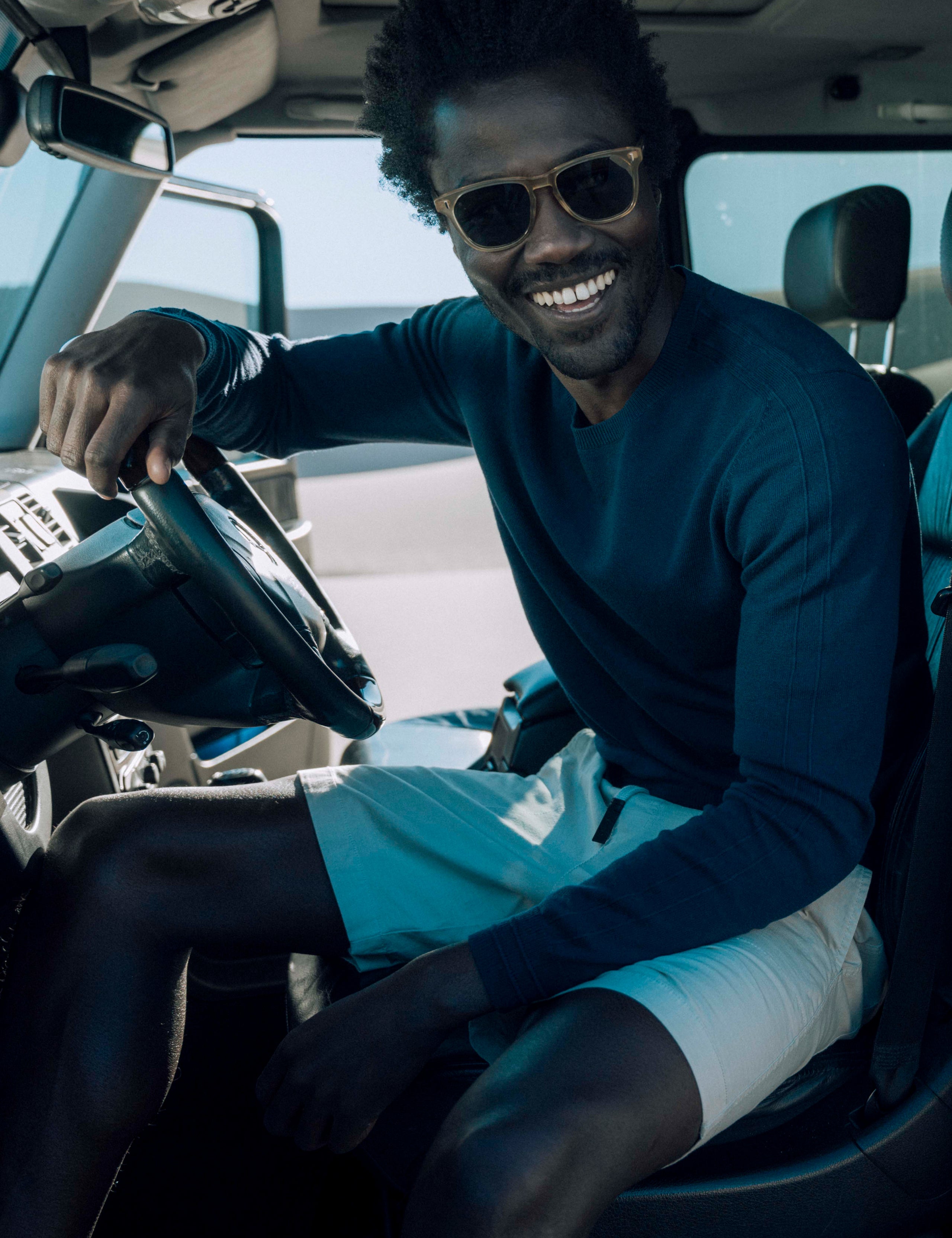 Man in car wearing blue sweater