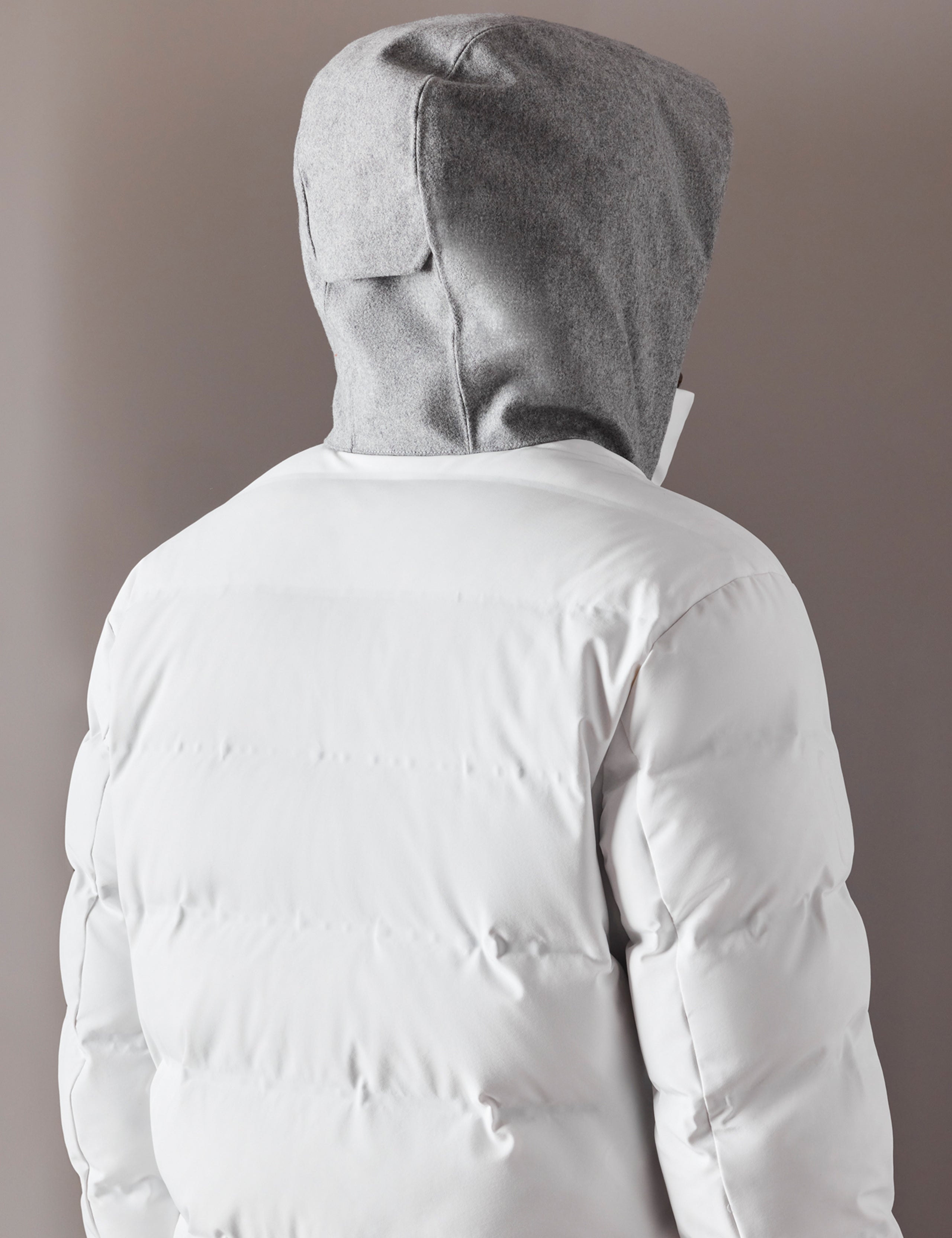 back view of man wearing white ski jacket from AETHER Apparel