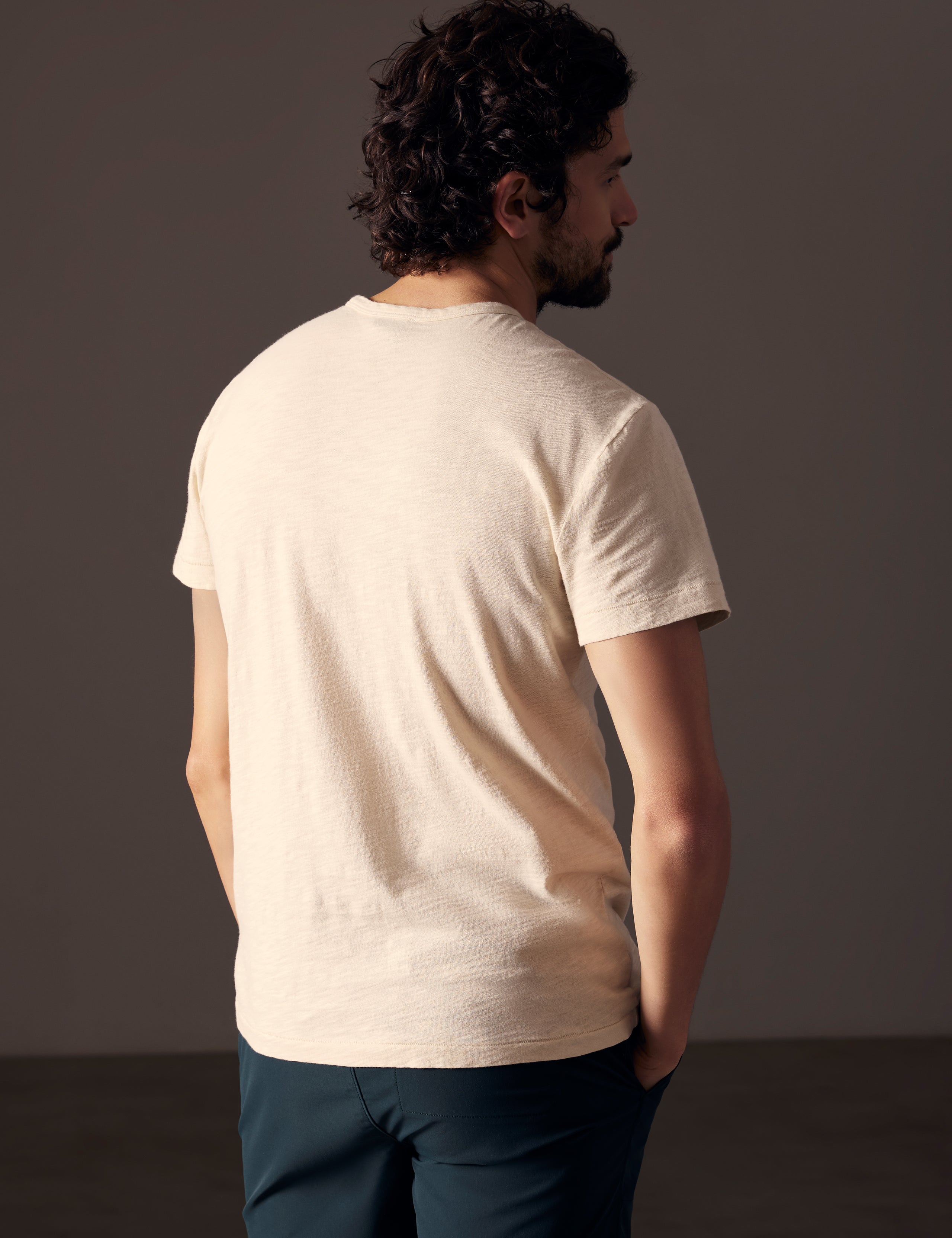 back view of man wearing beige tee from AETHER Apparel