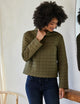 woman wearing quilted green pullover
