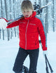 Woman holding skis walking through snowy forest in the W Nordic Jacket