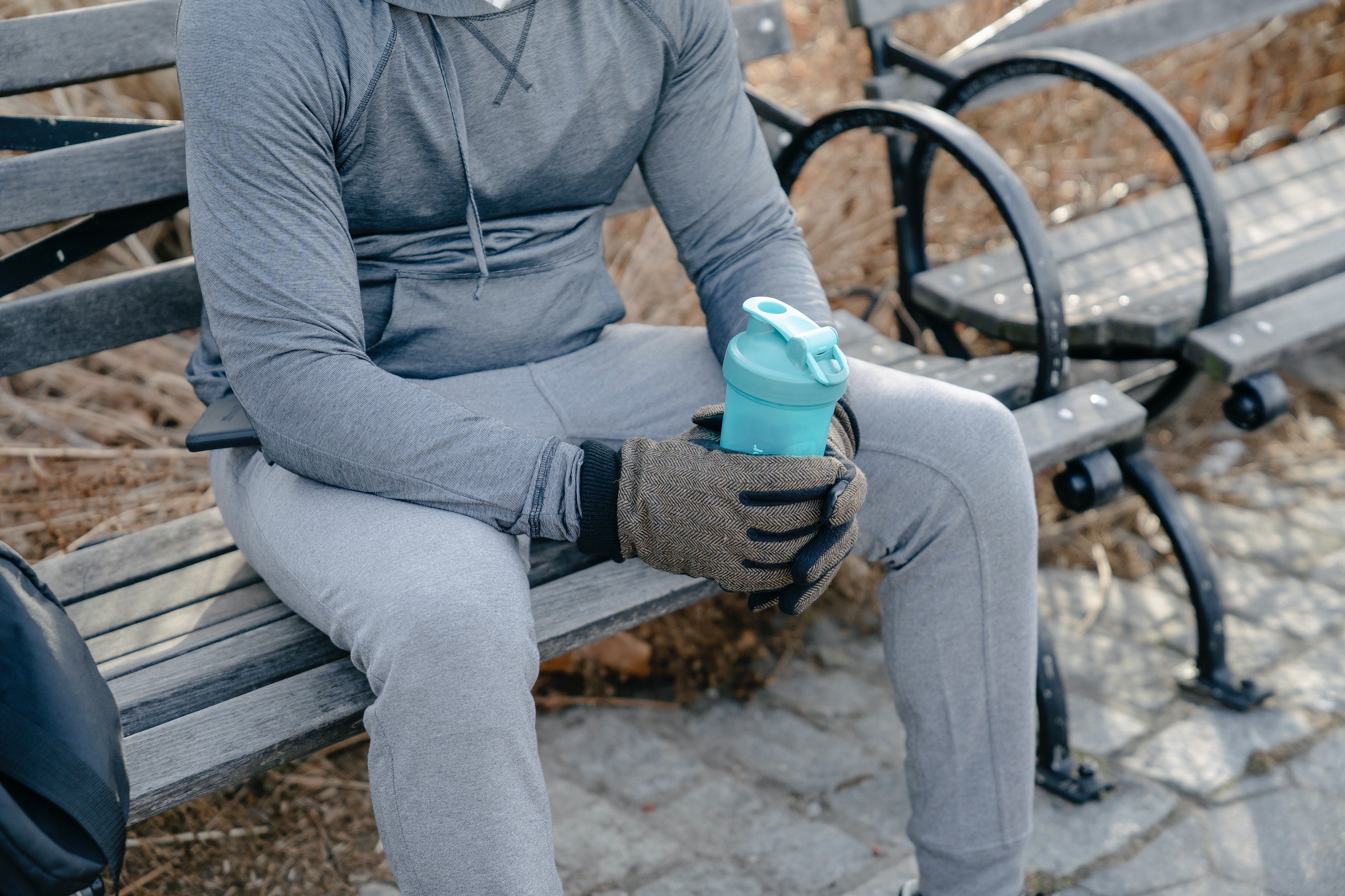 man with workout drink on bench