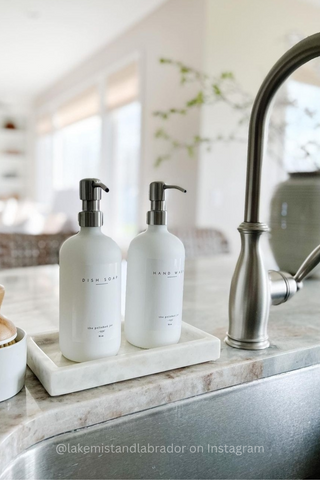 Soap bottle dispensers on tray over kitchen counter