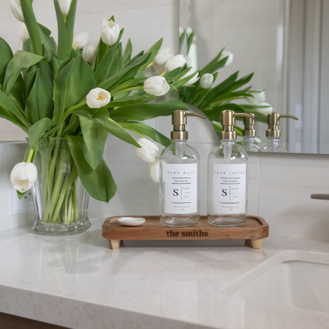 The Polished Jar Soap Bottle Dispensers on Wood Tray on Bathroom Counter Near Flower Arrangement