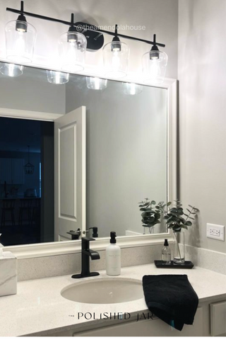 Bathroom countertop with mirror, black detail and soap bottle dispensers