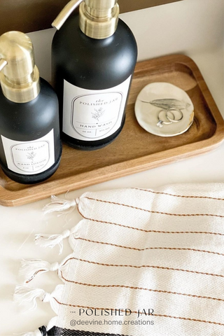 The Polished Jar bottle dispensers next to ring dish and hand towel
