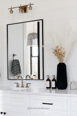 Modern White Bathroom Space Decorated With Black Accessories and Glass Bottle Soap Dispensers