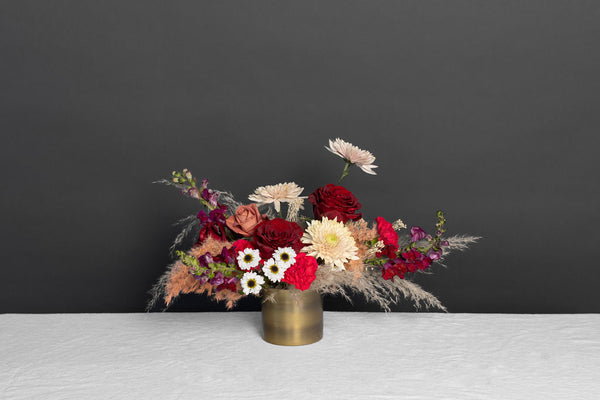 We Belong Together Flower Arrangement includes vibrant reds, dark purples, and dried pieces 