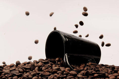 Mug falling on coffee beans