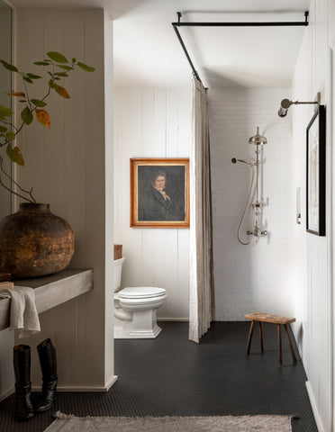 bathroom with black penny tile flooring