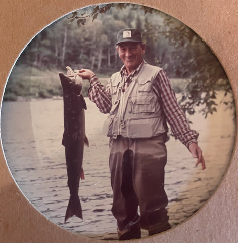 George Fletcher dressed to fly fish and holding a fish half his height