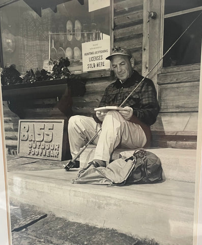George Fletcher looking through his fishing fly box, sitting on the steps of the Rangeley Region Sport Shop in Rangeley, Maine