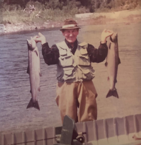 a smiling George Fletcher holding two large fish