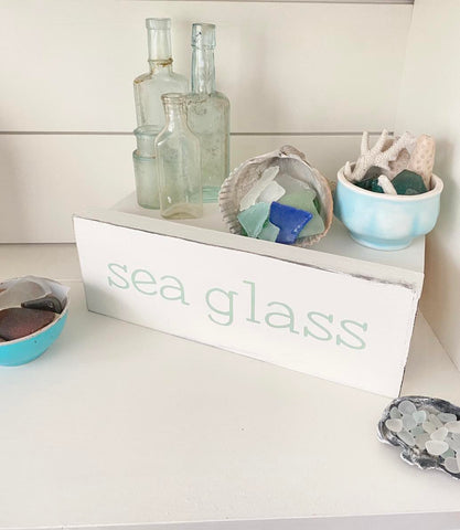 Elegantly arranged shell-filled jars on a coastal-themed shelf