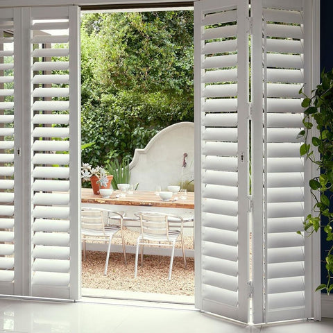 Bright coastal living room with white plantation shutters