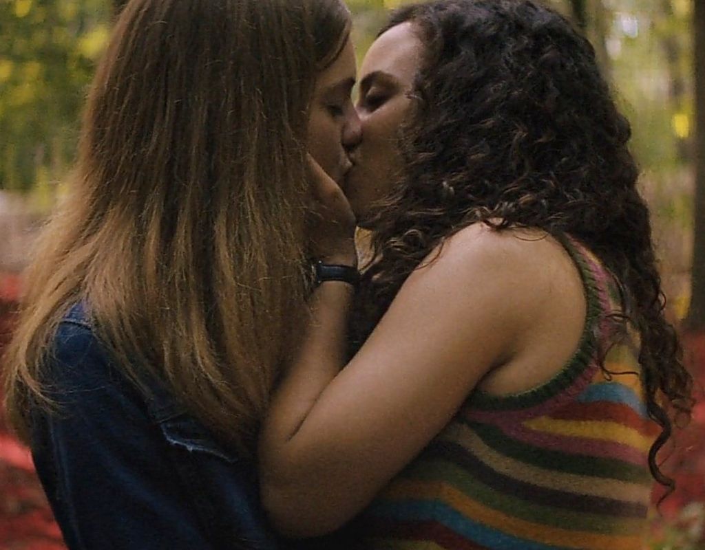 Fear Street is a horror movie trilogy featuring two main lesbian couples. In the image, they are kissing passionately in the woods.