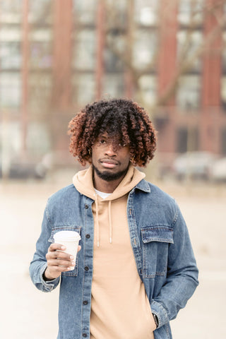 Man wearing a denim button up shirt under a hoodie