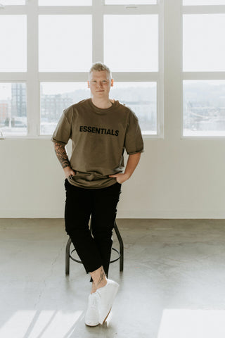 Model wearing a fitted t-shirt, black pants, and white sneakers.