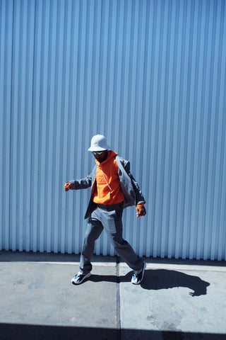 Man dancing wearing a suit with hoodie