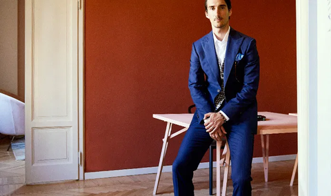 Man wearing a suit sitting on a table