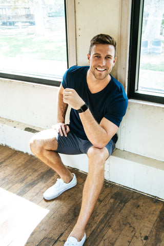 Man sitting down wearing a True Classic Navy V-Neck T-Shirt