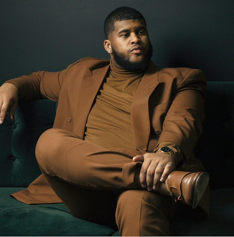 Big guy wearing a brown suit 