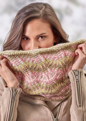 woman wearing a brioche cowl in pinks an tans