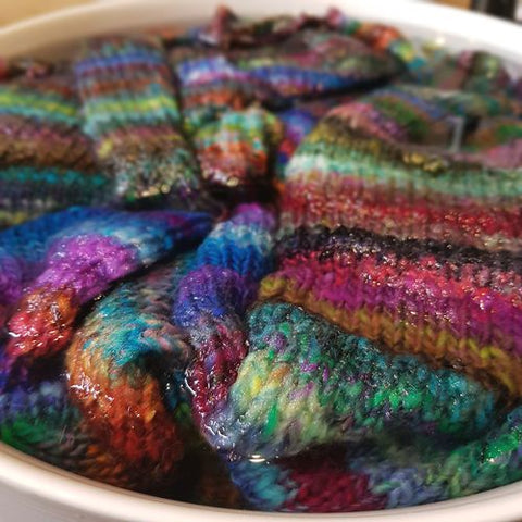 hand knit colorful stripey wool sweater soaking in water ready for blocking felix sweater