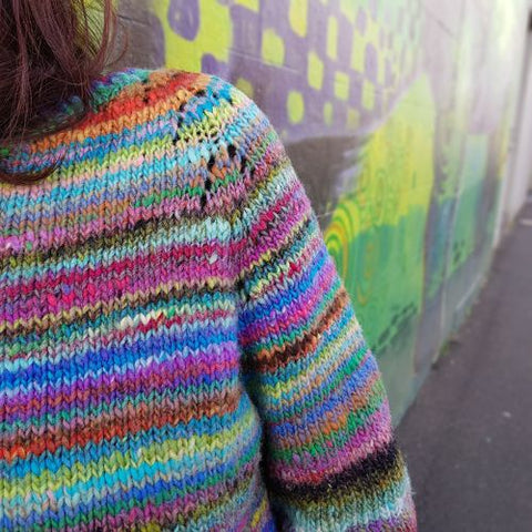 close up detail of felix sweater knit in noro ito colorful self striping yarn showing yarnover eyelet raglan detail