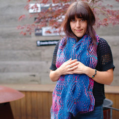 woman wearing nancy marchant's willow brioche scarf knit in shades of blue and purples and pinks