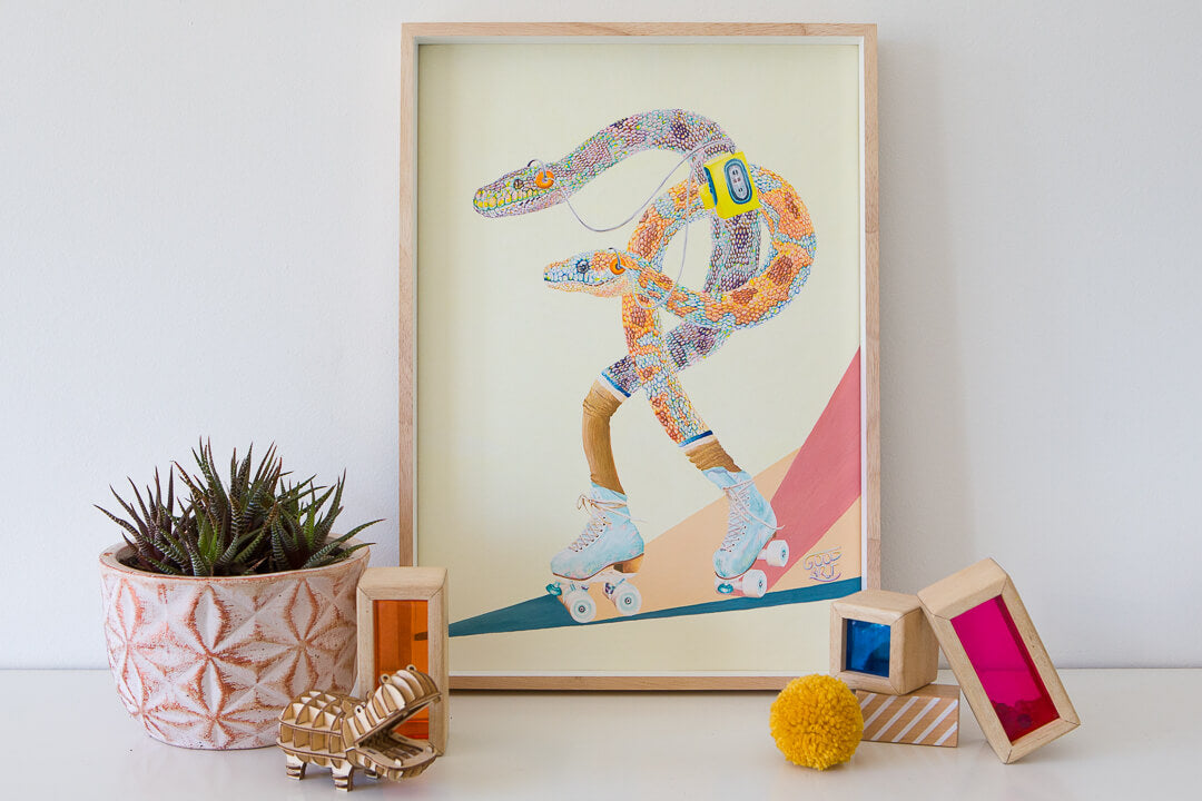 Art Print of a snake by Good Art Australia. Arranged on a shelf with plant and childrens toys.