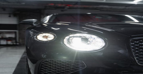 A black car with shining headlights