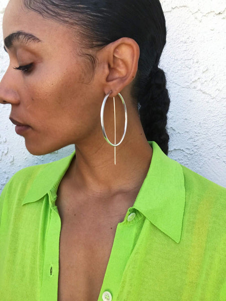 Close up of Courtney wearing a green carigdan top and silver earrings.