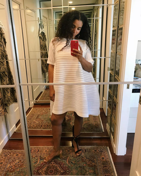 Courtney takes a mirror selfie in a white mini dress.