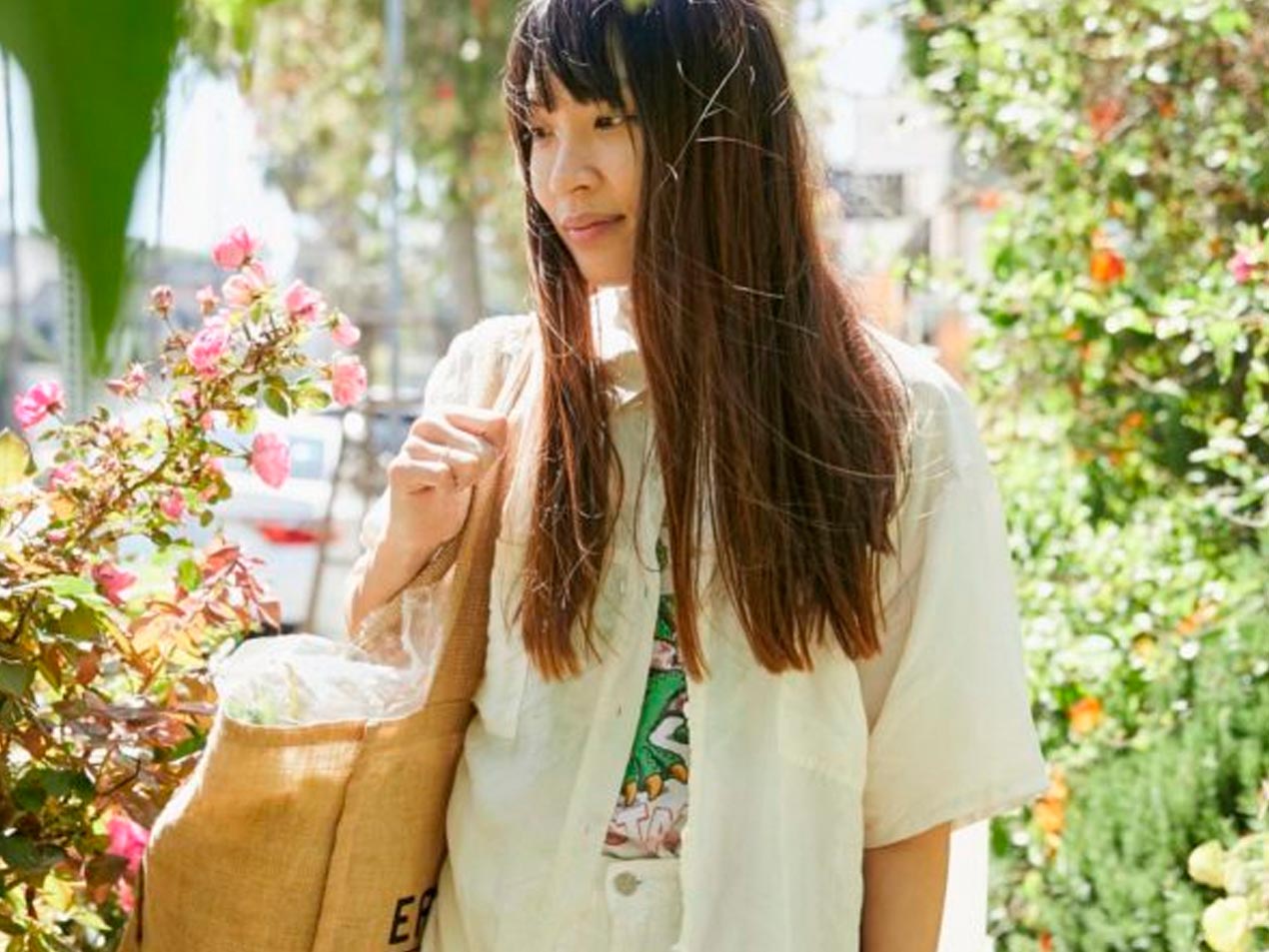 Chef Sandy Ho walking among in a garden.