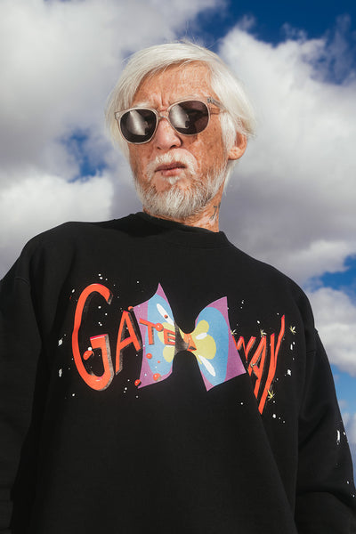 Photo of an elderly Asian man wearing sunglasses and a black Aries graphic sweatshirt.