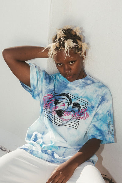 Close up photo of a model wearing the blue and white tie dyed Aries warped eyes short sleeve tee.