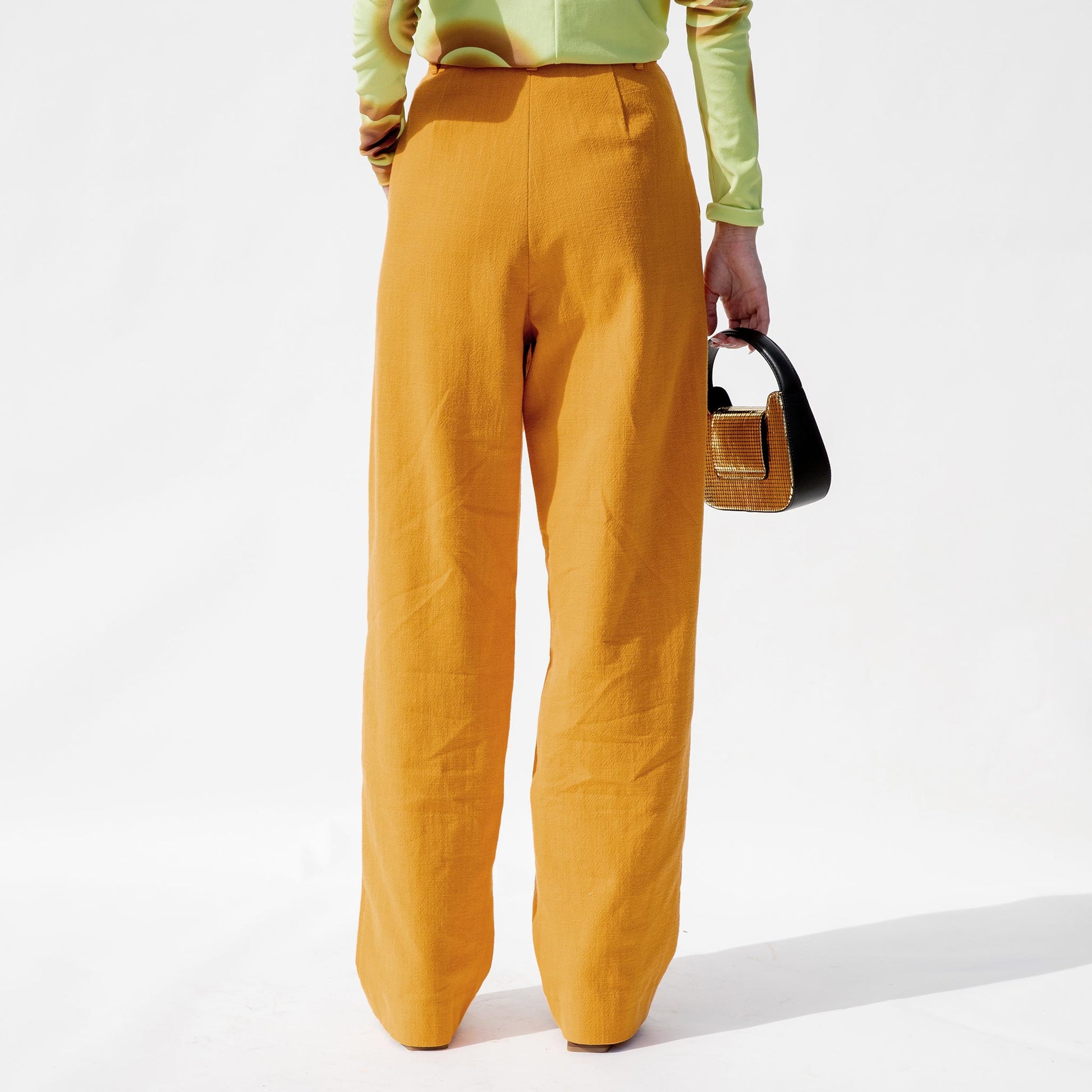 Back half body photo of model wearing the Marella Pant - Mustard.