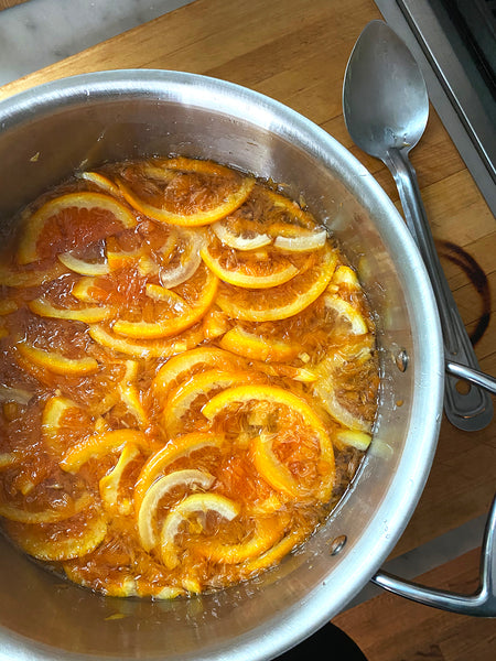 Oranges and lemons simmering in a pot.