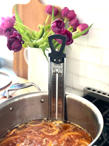 A candy Thermometer measures the temperature of the marmalade as it cooks. 