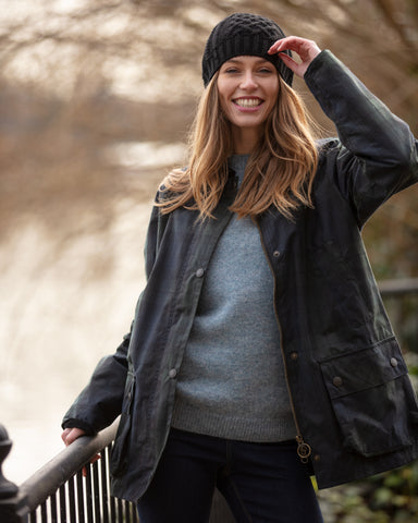 Lady wearing wax Landowner jacket holding rail beside river