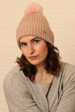 Lady wearing pink fluffy pom pom beanie hat