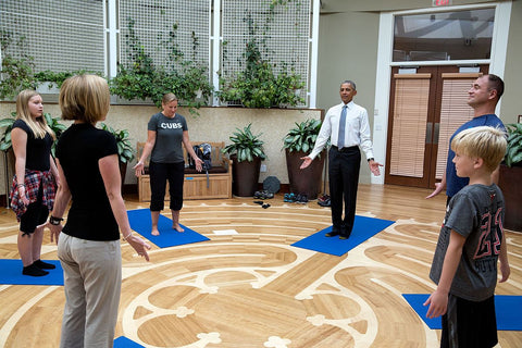 President Obama and military family doing yoga on the NICOE labyrinth