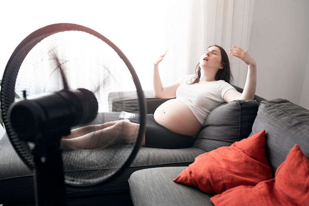 pregnant woman fanning herself to prevent nausea